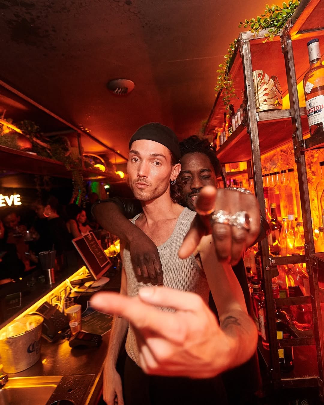 Deux hommes posent dans l’ambiance tamisée du bar du Kube Hotel à Paris, cadre branché et festif d’une soirée célibataires.