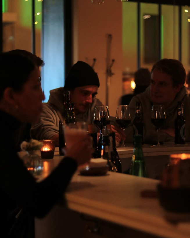 hommes buvant un verre de vin dans un bar