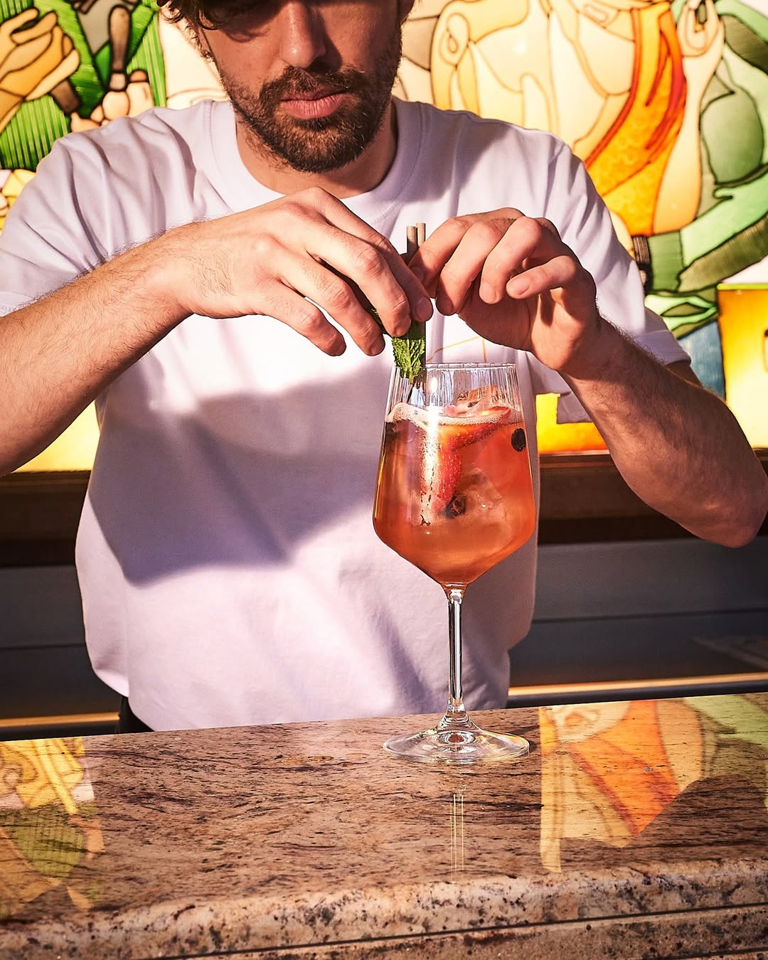 Barman du Montijo à Paris préparant un cocktail artisanal au bar, ambiance chaleureuse et colorée